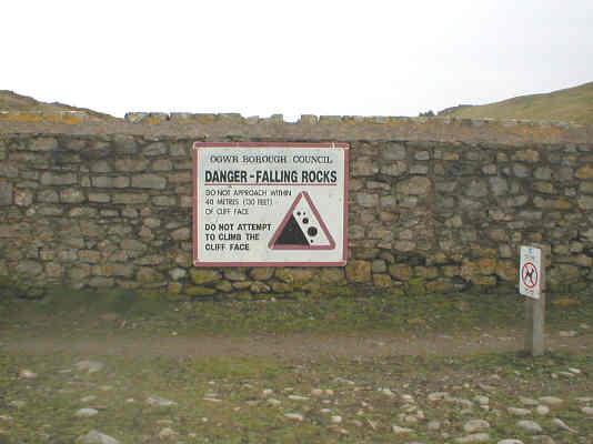 Signage warning not to attempt to climb the cliff face owing to the danger of falling rocks